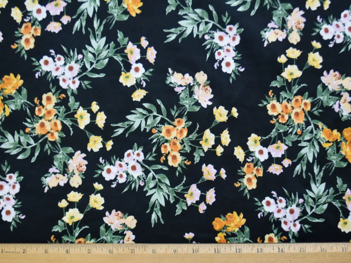 double brushed polyester spandex jersey fabric with black background and orange floral bouquet pattern with ruler to how the pattern size repeat