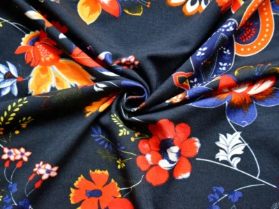 Rayon/spandex jersey fabric with navy background and orange floral and paisley print